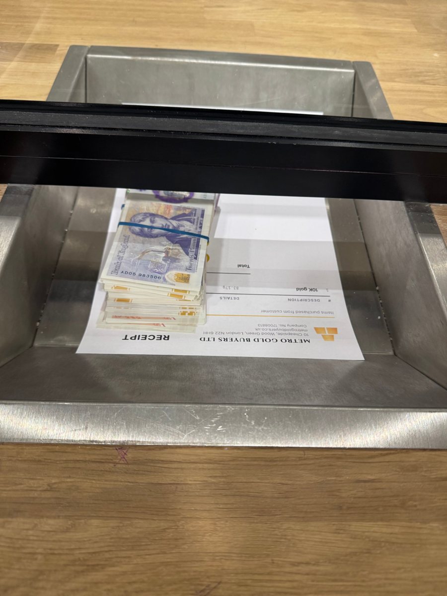 Cash bundle on the counter beside the purchase receipt, which lists the 10K gold item and the total