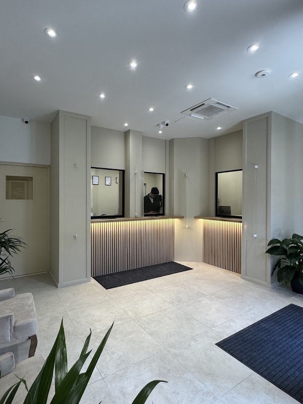 Inside the Metro Gold Buyers shop: a bright, light-coloured counter with timber panelling and a staff member behind the glass